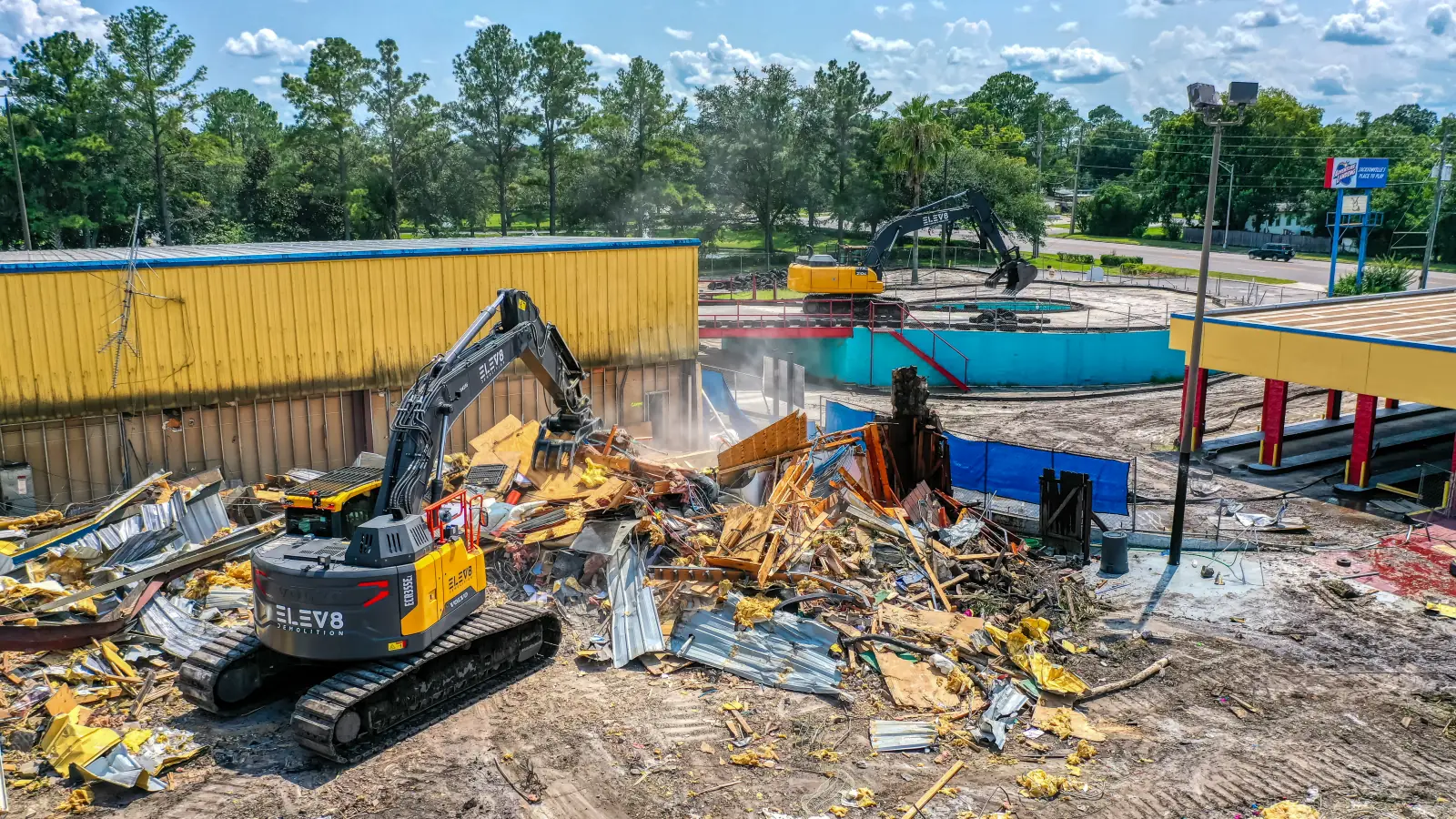 ELEV8 excavators taking down water-park buildings at Adventure Landing, Jacksonville, with the park sign in frame